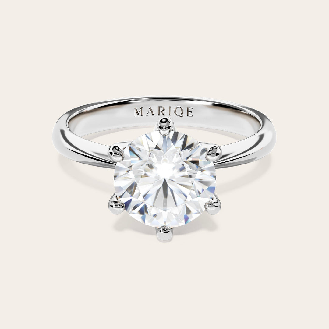 Eterna moissanite solitaire ring front view on tan background