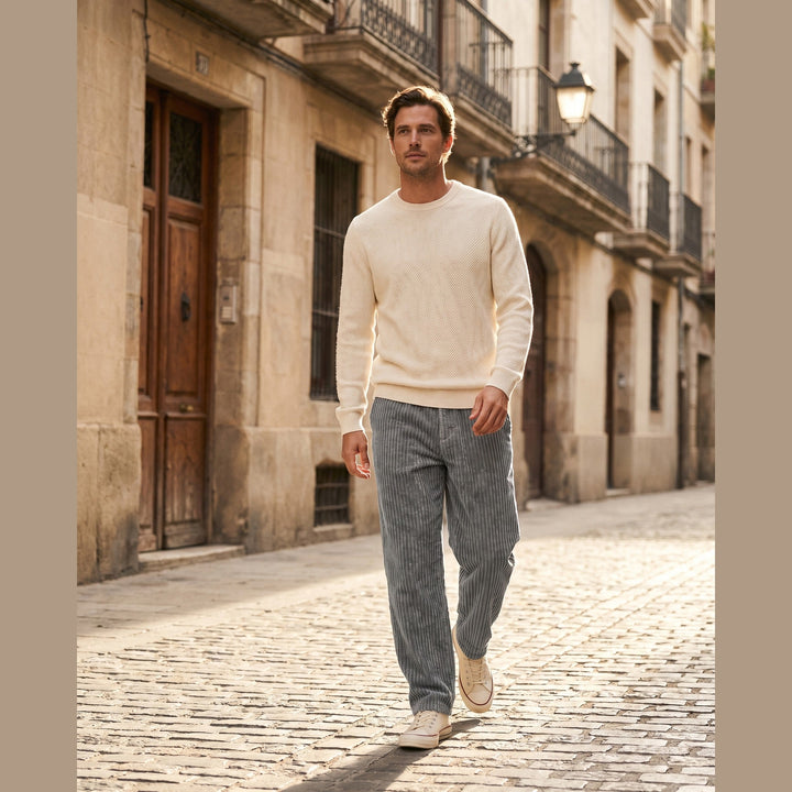 Man wearing Monaco corduroy trousers walking a sunlit street