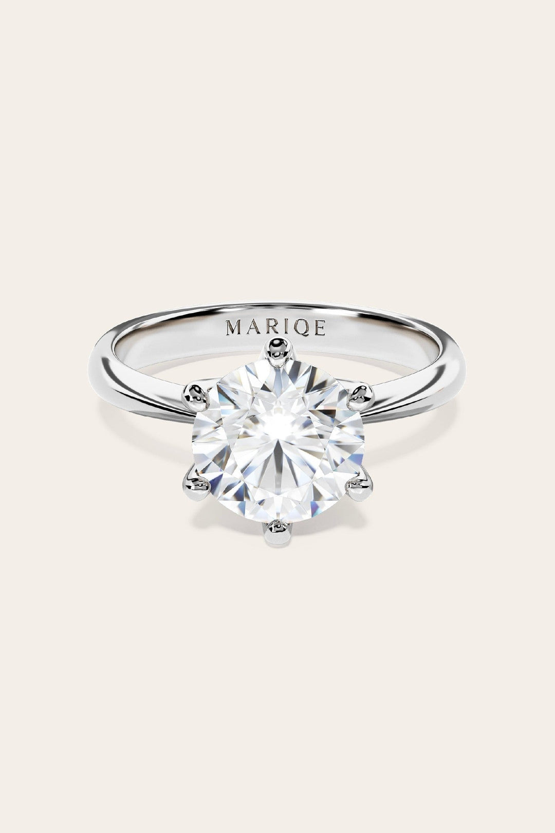 Eterna moissanite solitaire ring front view on tan background