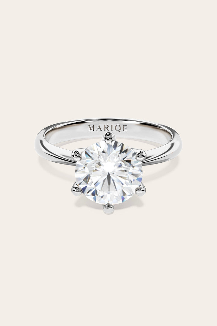 Eterna moissanite solitaire ring front view on tan background
